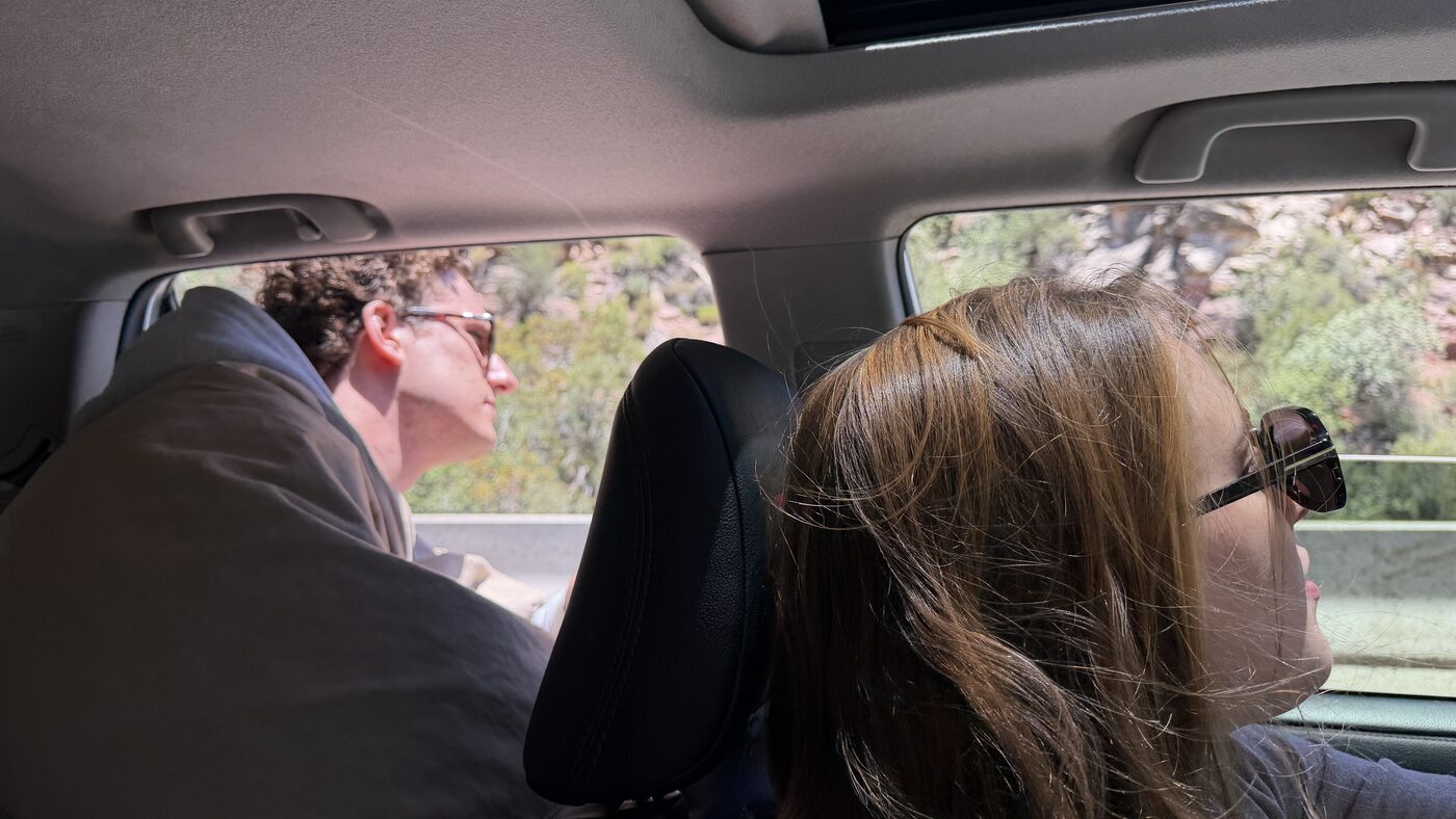 Two people in a car on a desert road trip